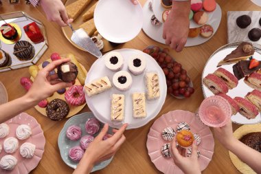 İnsanlar açık büfeden farklı tatlılar ve içecekler alıyor.