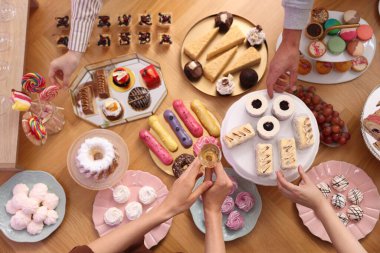 İnsanlar açık büfeden farklı tatlılar yiyorlar.