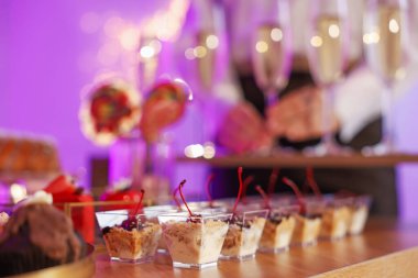 Different delicious desserts on buffet table and waiter, selective focus
