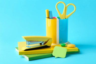 Açık mavi arkaplanda zımba ve diğer kırtasiye malzemeleri