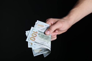 Siyah arka planda dolar banknotları olan adam, yakın plan.