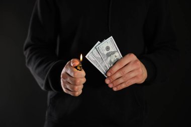 Siyah arka planda dolar yakan adam, yakın plan.