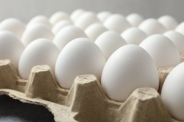 Yumurta kartonunda çiğ tavuk yumurtası, yakın plan.