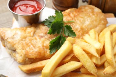 British Traditional Fish and chips served with sauce on table, closeup