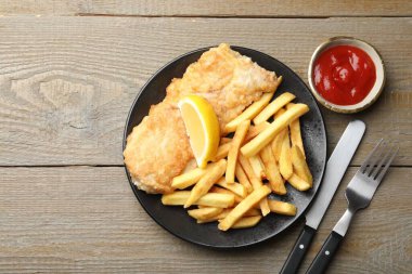 Geleneksel İngiliz Balık ve patates kızartması ahşap masada servis edilir. Metin için boşluk