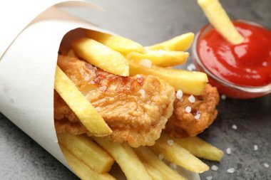 British Traditional Fish and chips with sauce on grey table, closeup