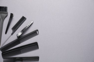 Different hair styling tools on grey background, flat lay. Space for text