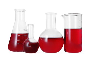 Different laboratory glassware with red liquid isolated on white