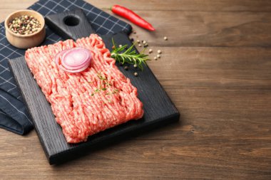 Biberiyeli çiğ et, kekik ve baharatlar ahşap masada, yakın plan. Metin için boşluk