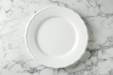 Beyaz mermer masada seramik tabak, üst görünüm.