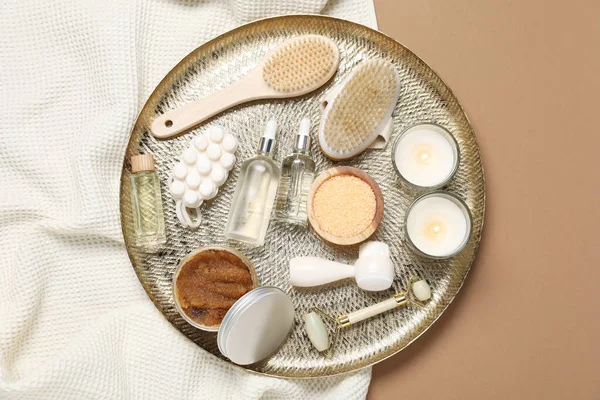 Beautiful composition with spa essentials on brown background, top view