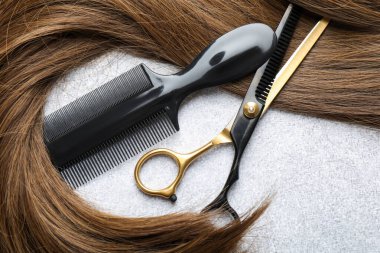 Beautiful hair strand and hairdresser's tools on light background, flat lay