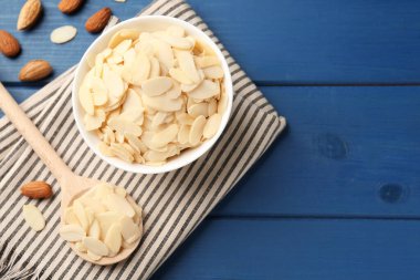 Taze badem gevrekleri ve mavi ahşap masada fındıklar. Metin için boşluk