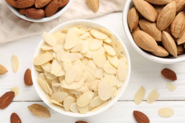 Taze badem gevrekleri ve beyaz ahşap masada fındıklar.