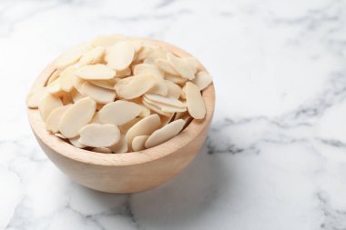 Beyaz mermer masada taze badem gevrekleri, yakın plan. Metin için boşluk