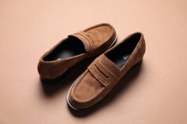 Kahverengi arka planda bir çift şatafatlı deri ayakkabı