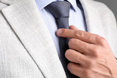 Takım elbiseli adam kravatını düzeltiyor.