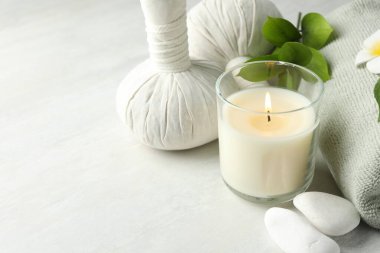 Güzel bir spa kompozisyonu, bitki torbaları ve beyaz masada yanan mumlar, yakın plan. Metin için boşluk