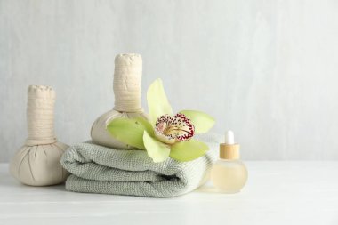 Beautiful spa composition with herbal bags on white wooden table, space for text