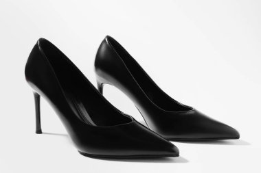 Hafif arka planda şık topuklu ayakkabılar, yakın plan.