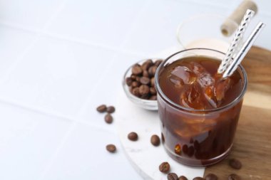 Lezzetli buzlu kahve, süt ve fasulye beyaz masada, yakın plan. Metin için boşluk