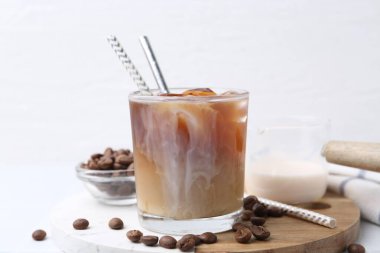 Sütlü buzlu kahve ve beyaz masada fasulye.