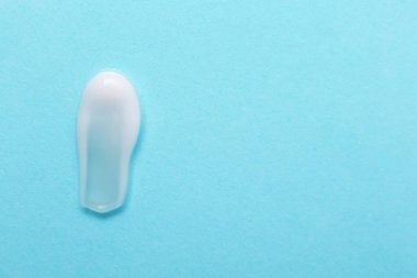 Açık mavi arka planda nemlendirici krem örneği. Metin için boşluk