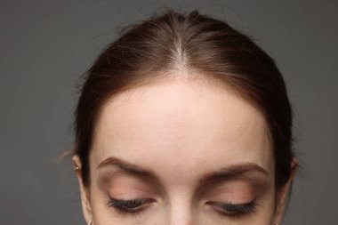 Gri arkaplandaki kadının yakın görüntüsü