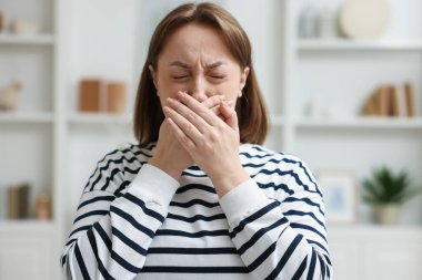 Evde mide bulantısı çeken genç bir kadın.