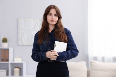 Ofisinde defter ve kalem olan profesyonel psikoterapist.