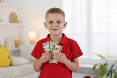 Evde cep harçlığı tutan küçük çocuk.