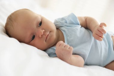 Evdeki yatakta uzanmış tatlı bir bebek.