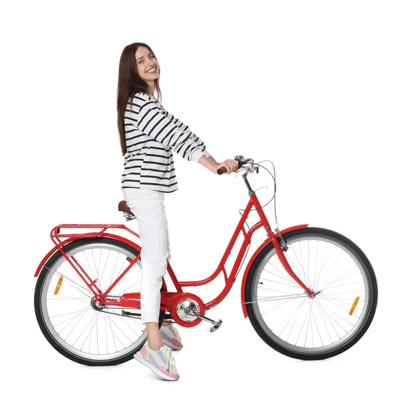 Kırmızı bisiklette beyaz arka planda poz veren gülümseyen kadın.