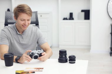 Stüdyoda beyaz masada klasik kamerası olan profesyonel fotoğrafçı, mesaj için yer var.