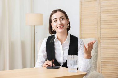 Podcast sunucusu stüdyoda mikrofona konuşuyor