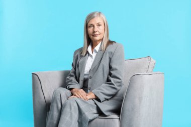 Açık mavi arka planda koltukta profesyonel psikoterapist