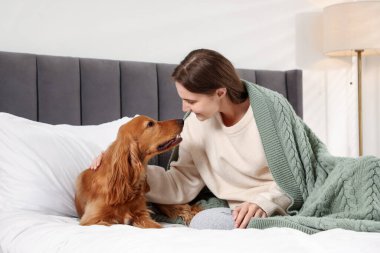 Evcil hayvan dostu otel. Kadın ve sevimli köpeği yatağın içinde