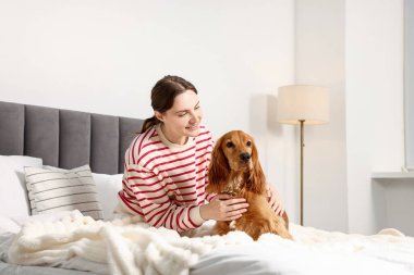 Evcil hayvan dostu otel. Kadın ve sevimli köpeği yatağın içinde