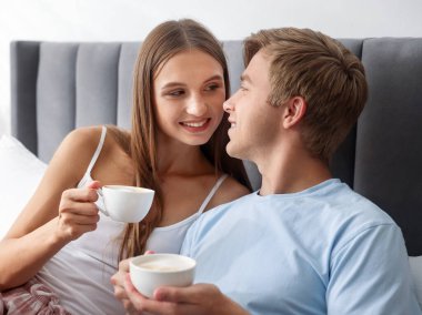 Hoş bir çift evde sıcak içeceklerin tadını çıkarıyor.