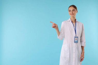 Açık mavi arka planda rozeti olan profesyonel hemşire, metin için boşluk