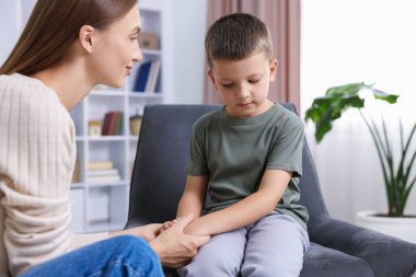 Annesi evde üzgün oğluyla el ele tutuşmuş.