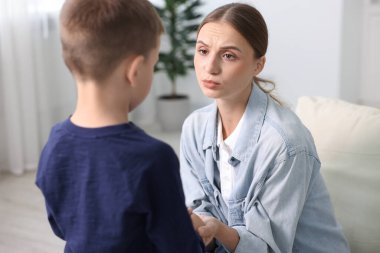 Anne, üzgün oğlunu evde destekliyor.