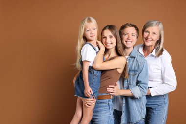 Kahverengi arka planda oğlu ve ailesi olan yaşlı bir kadının portresi. Metin için boşluk