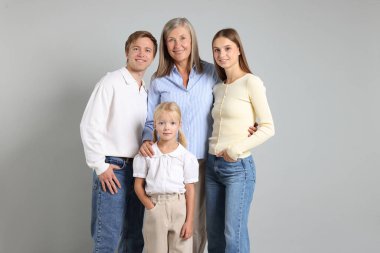 Aydınlık bir arkaplanda oğlu ve ailesi olan yaşlı bir kadının portresi.