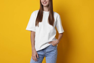 Turuncu arka planda beyaz tişört giyen kadın, yakın plan. Tasarım için model