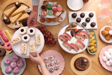 İnsanlar açık büfeden farklı tatlılar yiyorlar.