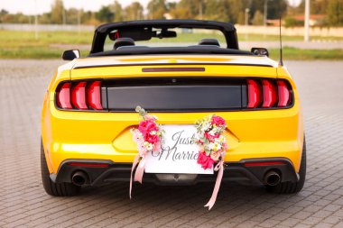 Düğün arabası. Cabriolet dekore edilmiş. Sadece evlilik kartı ve açık havada güzel çiçekler.