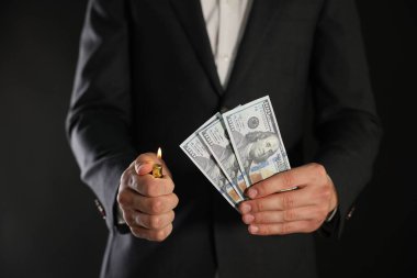 Siyah arka planda dolar yakan adam, yakın plan.