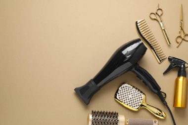 Different hair styling tools on beige background, flat lay. Space for text