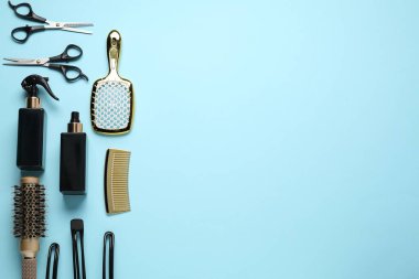 Different hair styling tools on light blue background, flat lay. Space for text